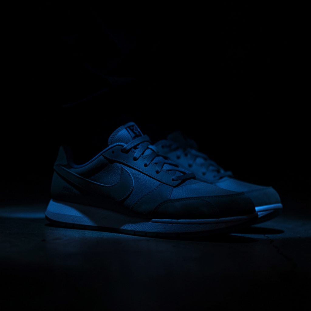 Heren Nike sneakers in een neutrale studioopname met zachte schaduw en aardetinten